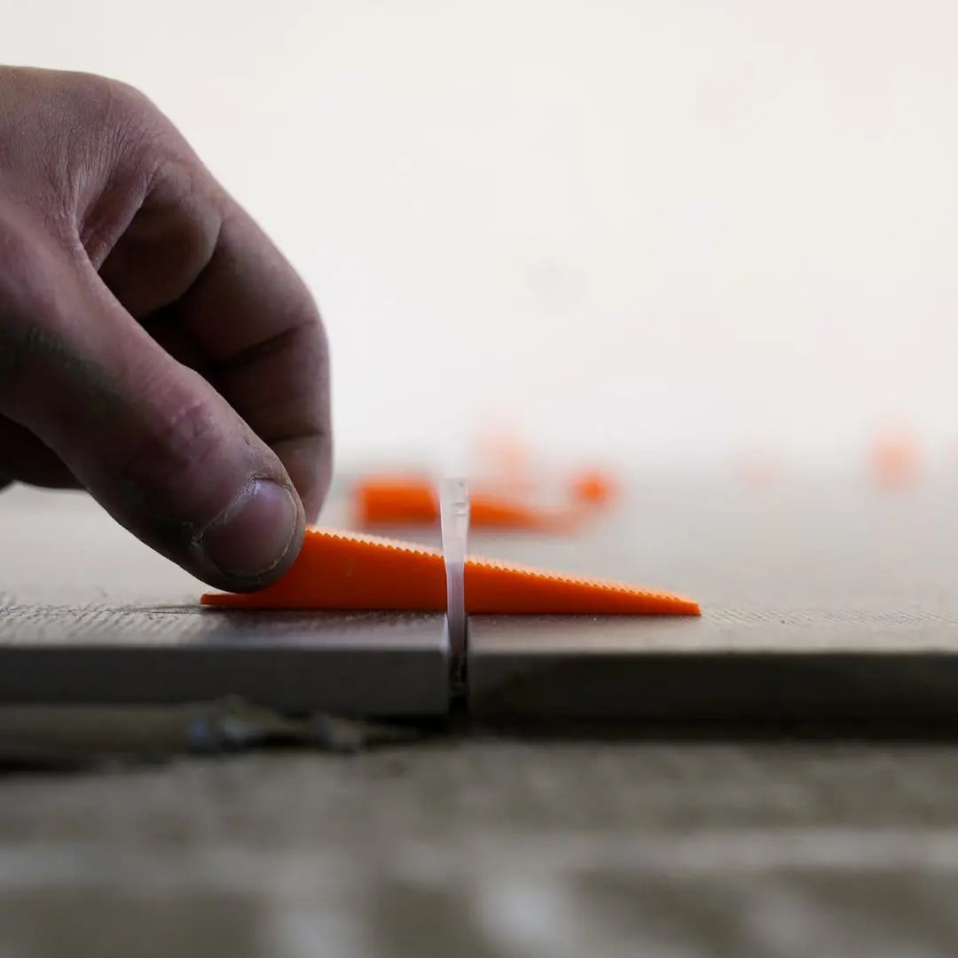 Levelit keggen in spie drukken met vingers om tegel te levelen.